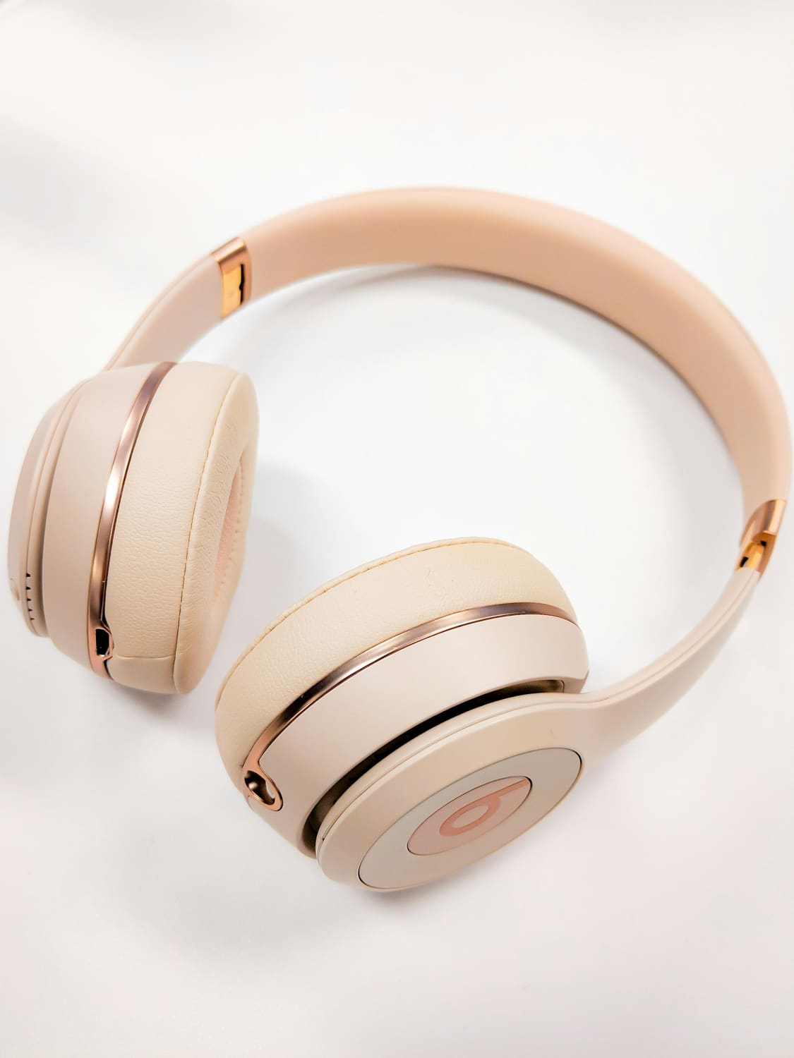 Beige wireless headphones on a white surface