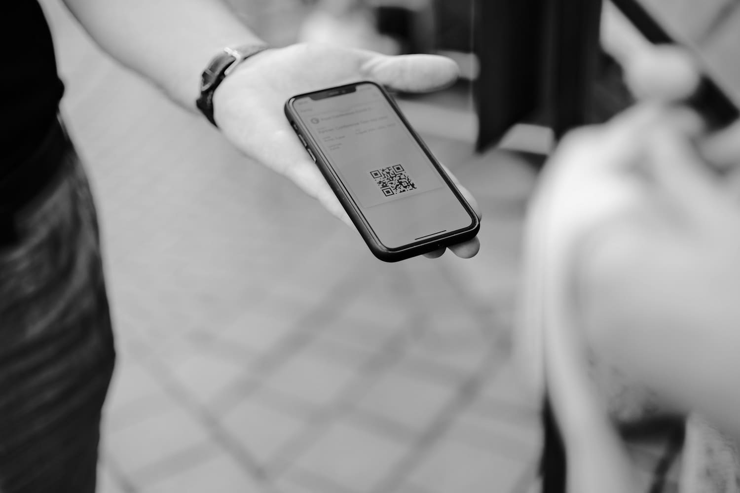 Hand holding a phone showing a QR code