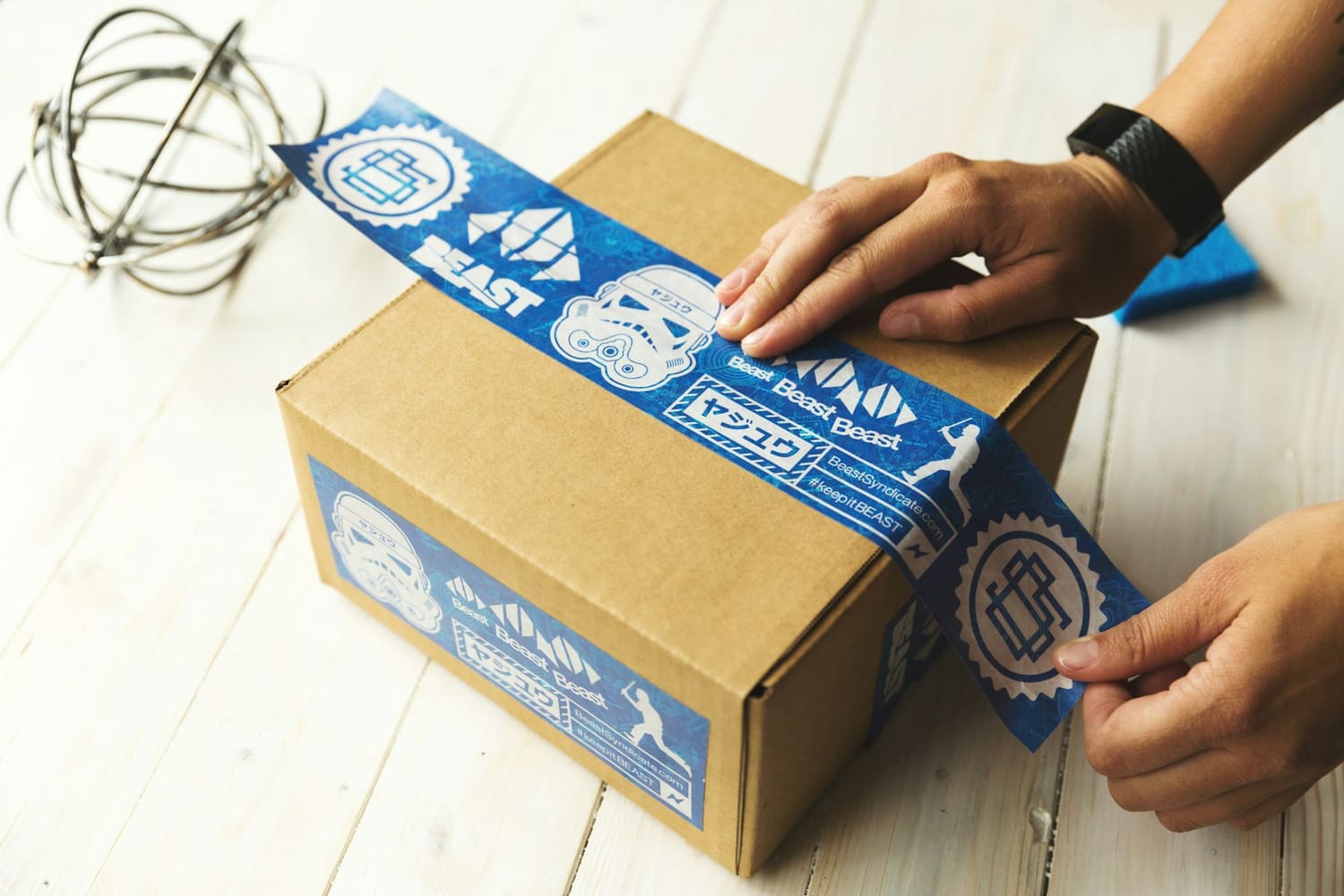 Hands sealing a cardboard box with tape
